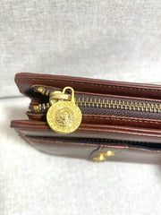 Vintage Gianni Versace brown leather wristlet, purse clutch, case bag with its iconic golden sunburst charms. Unisex bag. 061027y1
