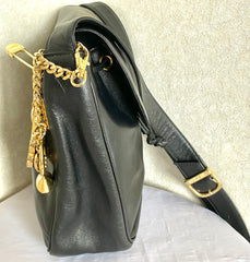 Vintage Moschino black leather shoulder bag with golden cute dangling charms. Heart, safety pin, trumpet, sacks, and guitar. 050725