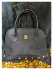 Vintage MCM black bolide style bag with gold tone metal studded charms. Rare masterpiece purse for unisex use. Phenomenon