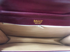 Vintage Bally wine leather clutch bag, party and classic purse with gold tone logo motif.