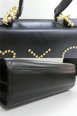 Vintage MOSCHINO black leather handbag in classic kelly purse style with golden studded heart, X, and O, playful motifs. Perfect daily bag