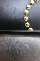 Vintage MOSCHINO black leather handbag in classic kelly purse style with golden studded heart, X, and O, playful motifs. Perfect daily bag