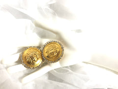 Vintage Gianni Versace large round gold tone medusa face earrings with crystal glasses. Must have Lady Gaga style jewelry piece.