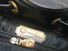 Vintage MCM black backpack with golden studded logo motifs and drawstrings. Designed by Michael Cromer. Unisex bag for daily use.