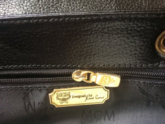 Vintage MCM black leather backpack with golden studded logo motifs. Designed by Michael Cromer. Unisex bag for daily use.